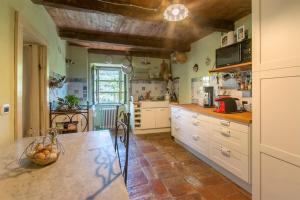a kitchen with white cabinets and a wooden ceiling at Casa Storica a Pennabilli in Valmarecchia in San Marino Rustico