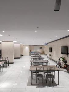 Cette grande chambre dispose de tables, de chaises et d'un écran. dans l'établissement فندق مناسك وقف عبدالقادر نصير, à La Mecque