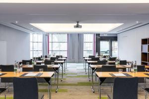 a dining room with tables and chairs and windows at Courtyard by Marriott Paris Saint Denis in Saint-Denis