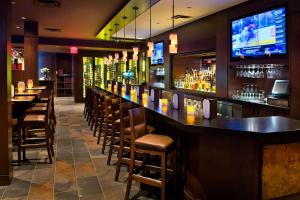 eine Bar in einem Restaurant mit Stühlen und einem TV in der Unterkunft Courtyard by Marriott Niagara Falls in Niagara Falls