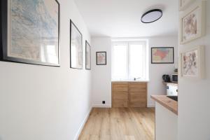 a living room with white walls and wooden floors at Motlawa River Apartment in Gdańsk