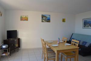 un salon avec une table et des chaises en bois dans l'établissement SP480-153 Maison 3 pièces SAINT PIERRE LA MER, à Saint Pierre La Mer