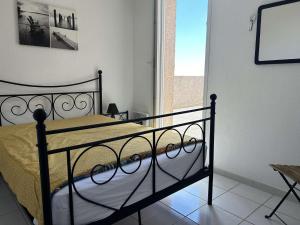 une chambre avec un lit noir dans une pièce dans l'établissement SP480-153 Maison 3 pièces SAINT PIERRE LA MER, à Saint Pierre La Mer