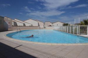 un homme nageant dans une grande piscine dans l'établissement SP480-153 Maison 3 pièces SAINT PIERRE LA MER, à Saint Pierre La Mer 8 autres photos