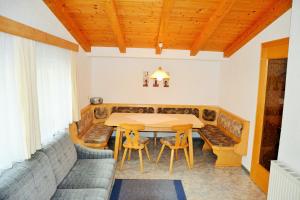 a dining room with a table and a couch at Ferienwohnungen Schöpf in Jerzens