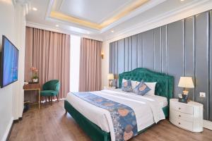 een slaapkamer met een groot bed met een groen hoofdeinde bij Le Haute Hotel Hai Phong in Hai Phong