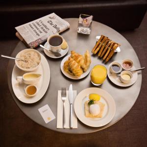 a table topped with plates of breakfast foods and coffee at Dakota Edinburgh in Queensferry
