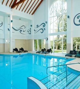 a swimming pool with a pool table and chairs at Dalmahoy Hotel & Country Club in Edinburgh
