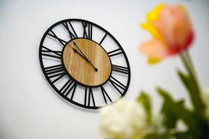 a clock on a white wall with a flower at Superb New Family Apartment VIPGreece in Athens +26 photos