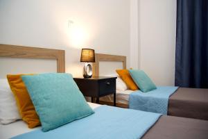 a hotel room with two beds and a lamp on a table at Superb New Family Apartment VIPGreece in Athens