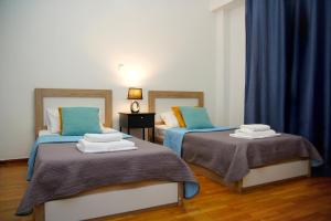 two beds in a room with blue curtains at Superb New Family Apartment VIPGreece in Athens