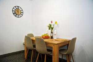 a wooden table with chairs and a bowl of fruit on it at Superb New Family Apartment VIPGreece in Athens