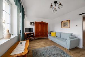 a living room with a couch and a tv at Motlawa River Apartment in Gdańsk