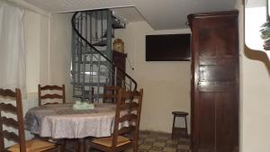 une salle à manger avec une table et un escalier en colimaçon dans l'établissement Gîte des pêcheurs, à Cantenay-Épinard