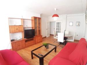 a living room with a red couch and a tv at Apartamento Cerca Estacion de Bus in Murcia