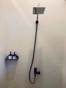 a shower with a hose attached to a wall at Diwas Stay in Yogyakarta +44 photos