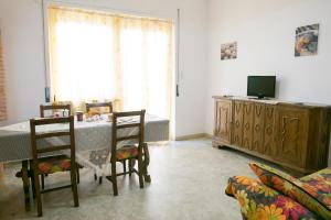 a living room with a table and chairs and a television at Edera Attico Pineto Vacanza in Pineto