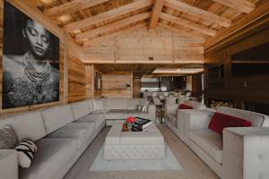 a living room with white furniture and wooden ceilings at Ultima Hotel Courchevel in Courchevel