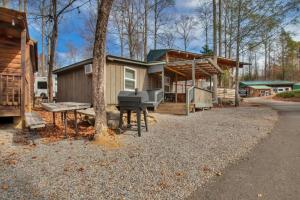加特林堡1BR Cabin in the Smokies Close to Gatlinburg的一间小房子,配有野餐桌和烧烤架