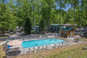加特林堡1BR Cabin in the Smokies Close to Gatlinburg的一个带椅子的大型游泳池和一栋房子