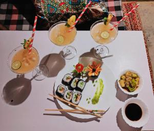 a white table topped with sushi and glasses of juice at MudHouse Retreat, Sarajara in Bīr