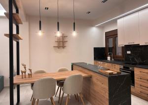 a kitchen with a wooden table and chairs at Abete Luxury Apartments in Metsovo