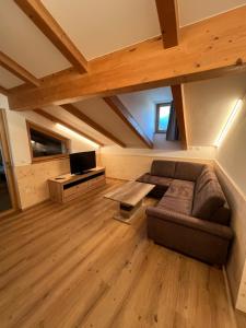 a living room with a couch and a tv at Apartment Ploseblick in Bressanone