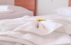 a white bed with a yellow tag on it at Hotel Kaiser in Berlin
