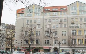 un gran edificio con coches estacionados frente a él en Hotel Kaiser, en Berlín