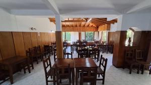 una sala da pranzo con tavoli e sedie in legno di Bagu Express a Villa Gesell