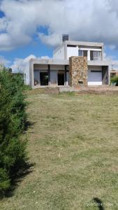 un bâtiment avec une pelouse devant lui dans l'établissement CASA QUINTA CON ESPECTACULAR VISTA Al RÍO, à General Alvear