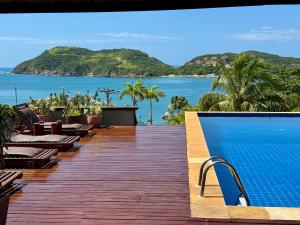 a resort with a swimming pool and a view of the ocean at Búzios Prime: Vista Mar, 50m da Praia da Ferradura, 8 suites in Búzios