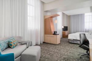 a hotel room with a bed and a couch at Courtyard by Marriott Niagara Falls, USA in Niagara Falls