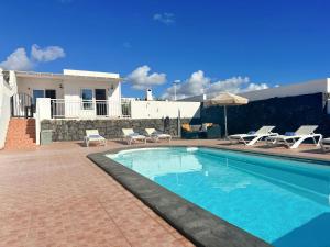 ein Swimmingpool vor einem Haus in der Unterkunft Villa Siempre Mar in Puerto del Carmen