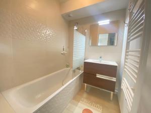 a bathroom with a tub and a sink and a mirror at Bel appartement proche du lac in Duingt +11 photos