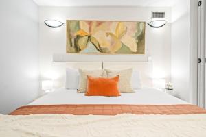 - une chambre avec un lit doté d'un oreiller orange dans l'établissement Tropical Tides at Cairns Esplanade, à Cairns