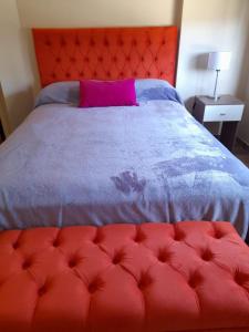 a red bed with a red headboard and a pink pillow at Complejo Médanos in San Bernardo