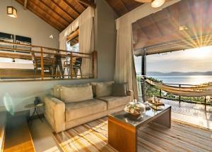 a living room with a couch and a balcony at Awasi Santa Catarina in Governador Celso Ramos