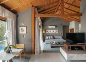 a living room with a couch and a tv at Awasi Santa Catarina in Governador Celso Ramos