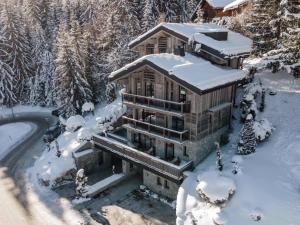 dom pokryty śniegiem w lesie w obiekcie Chalet luxueux à Courchevel avec piscine, cinéma, salle de sport et service complet - FR-1-562-71 w Courchevel