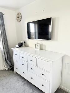 a white dresser with a tv on top of it at Rose home in Haverhill