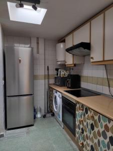 a kitchen with a refrigerator and a washing machine at Apartamento con piscina en Garrucha, Vera in Garrucha