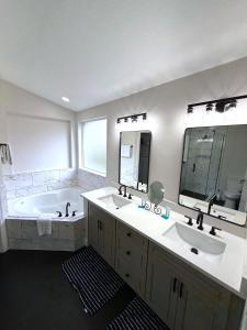 ヘインズ・シティにあるRemodeld South Facing Villa - Southern Dunes Golf Course Viewsの洗面台2つ、浴槽1つ、鏡1つを備えたバスルーム