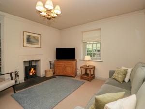 a living room with a couch and a fireplace at Upper Lodge in Bowness-on-Windermere