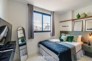 a small bedroom with a bed and a window at Apto c/ Vista Mar | 500m Praia Itapema DSH1702 in Meia Praia +17 photos