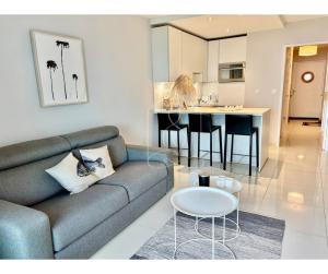 a living room with a couch and a table at LONDON CANNES, vue mer in Cannes
