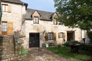 an old stone house with a courtyard in front of it at Gite du regourdel avec spa in Chirac