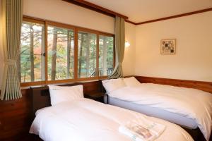 Postel nebo postele na pokoji v ubytování 軽井沢リゾートプチホテルみどり