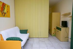 a living room with a white couch and a television at Monolocale con terrazzo a Sirolo - S052 in Sirolo