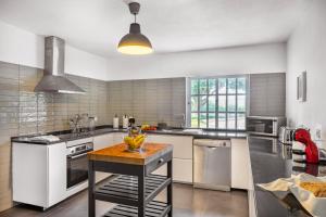a kitchen with a island in the middle of it at Canaan Boutique Casa do Monte by Get Your Stay in Boliqueime